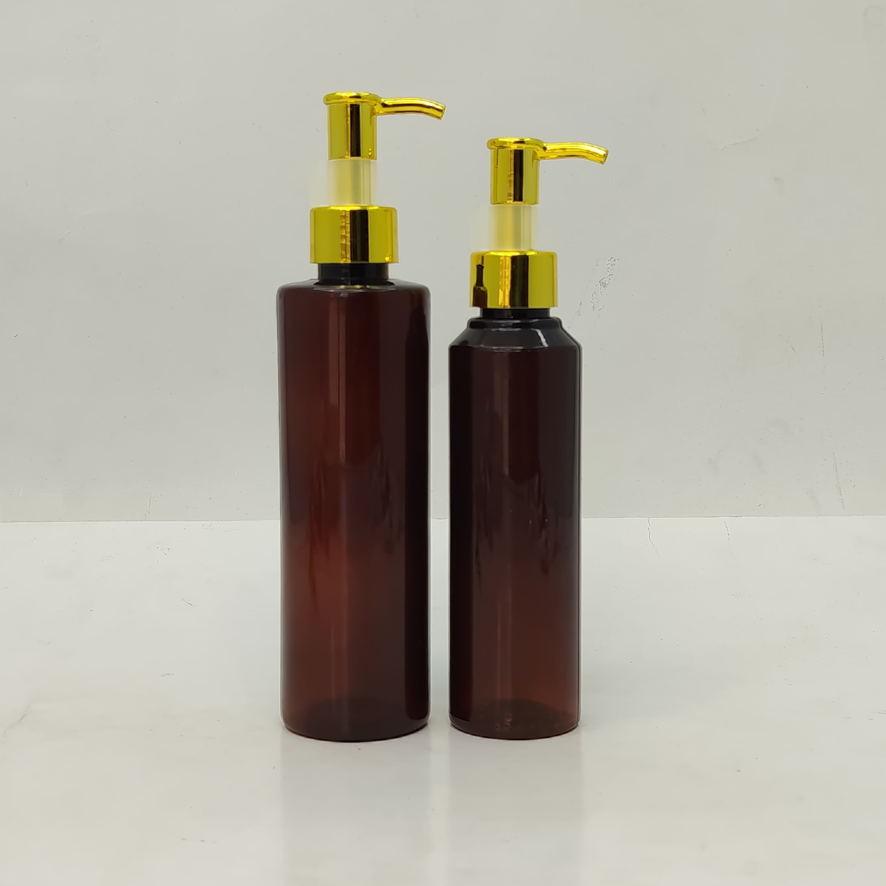 Main image of 150ml-200ml Round Amber Bottle - Gold Pump-Long Neck